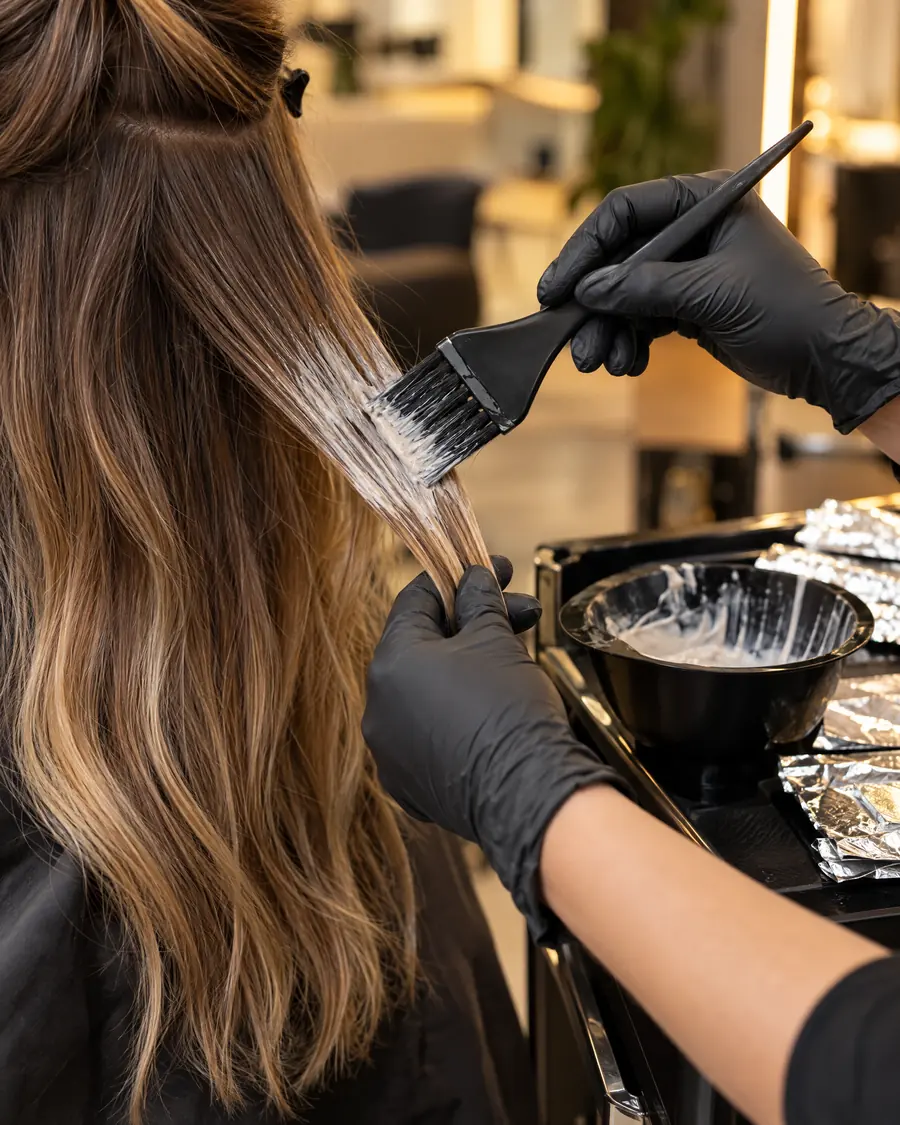 Litur verður málaður á langt hár við pensli til balayage